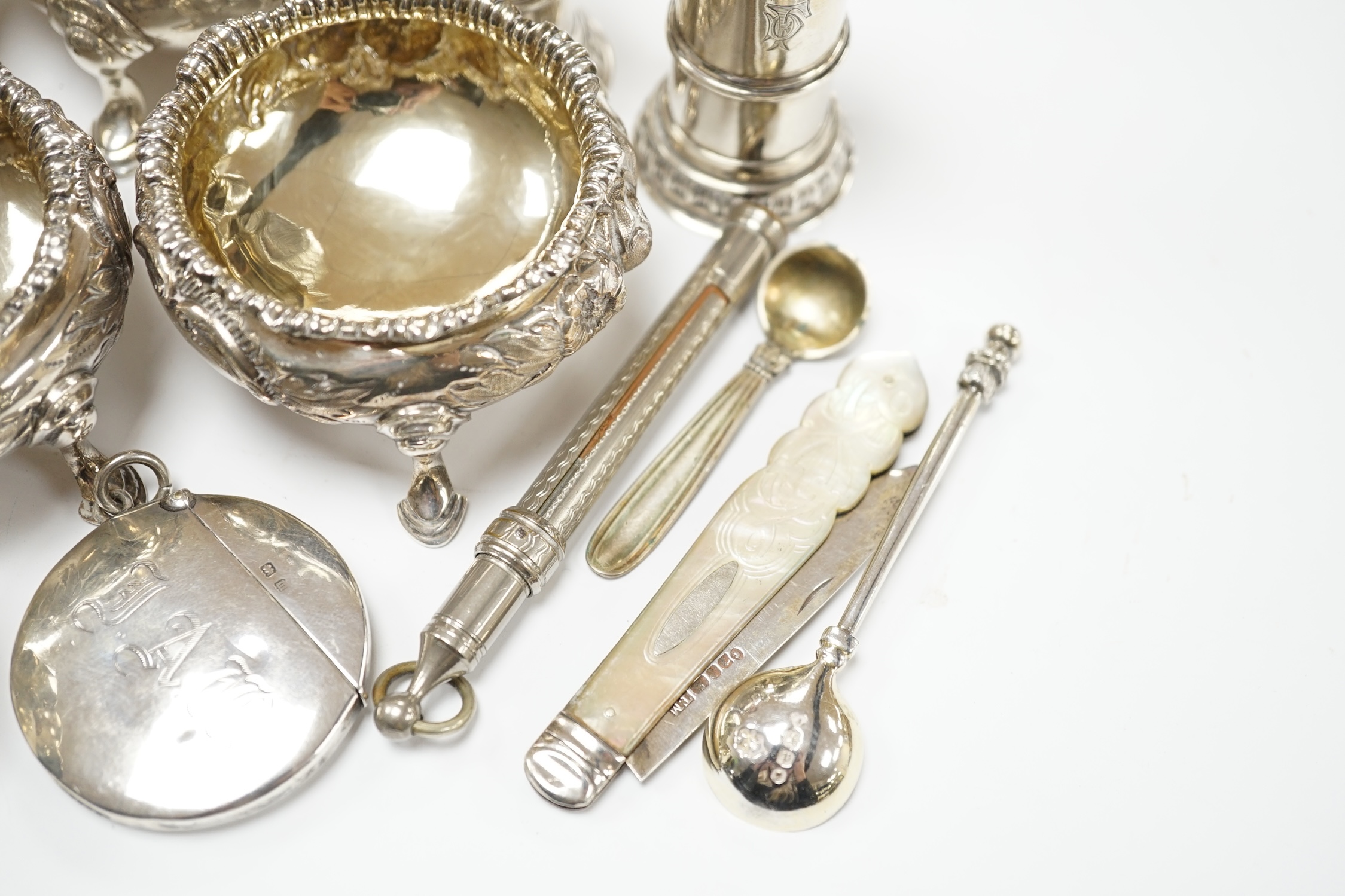 A pair of George II silver bun salts, London, 1735, diameter 60mm, a later pair of Victorian silver salts, a pair of Edwardian silver pepperettes by William Comyns and sundry other items including a circular silver vesta